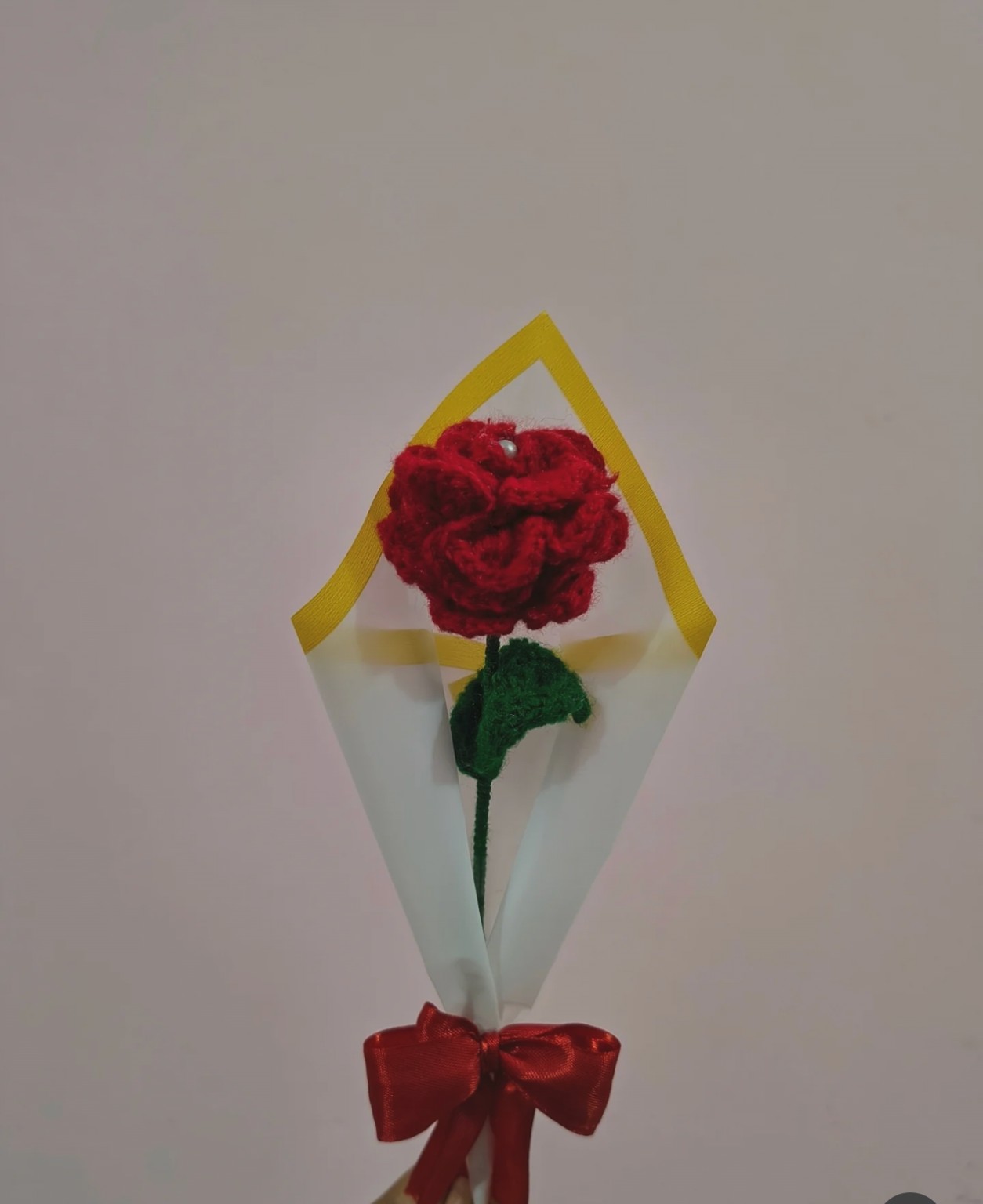 Handcrafted single red rose bouquet wrapped in boutique paper with satin ribbon